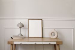 Modern round vase, beige lamp and old books with mock up wooden picture frame