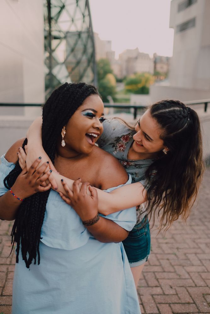 Multiethnic modern women embracing on street