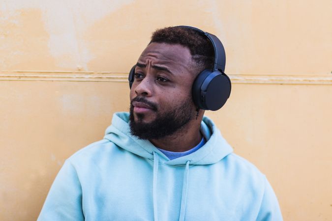 Optimistic Black hipster listening to music with headphones