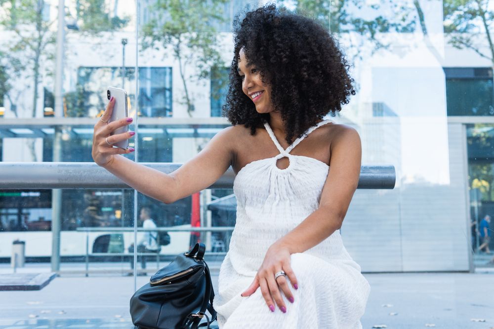 Pregnant Black woman taking self portrait with mobile phone
