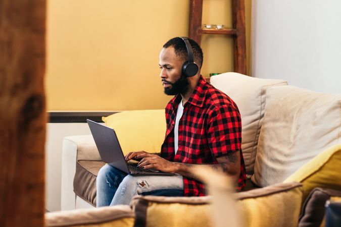Black man teleworking with laptop from home