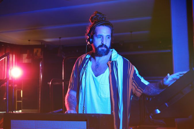 Bearded DJ playing music in club