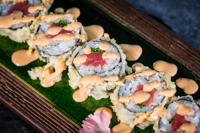Tasty sushi rolls served on tray on marble surface