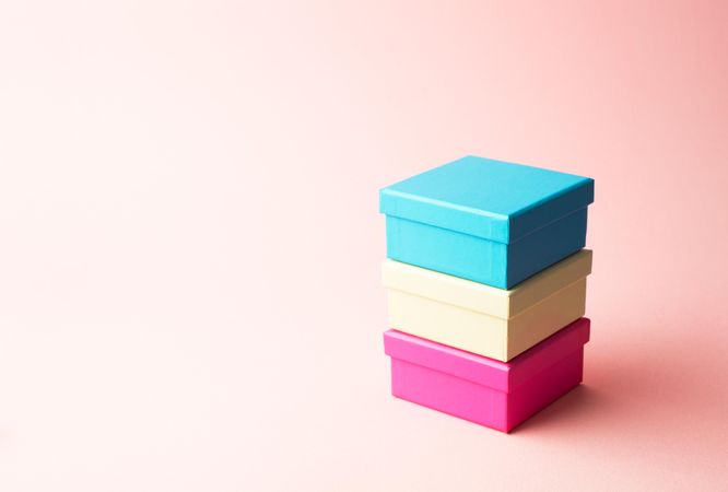Three stacked boxes on pink background right of frame