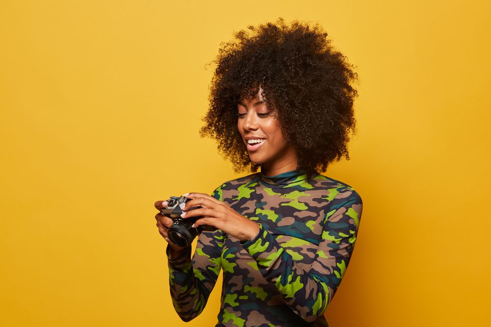 Trendy female paparazzi holding camera