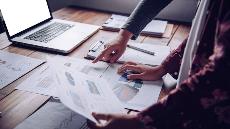 Business Team Analyzes Business ReportsTeam Analyzing Business ReportsMeeting on the Table