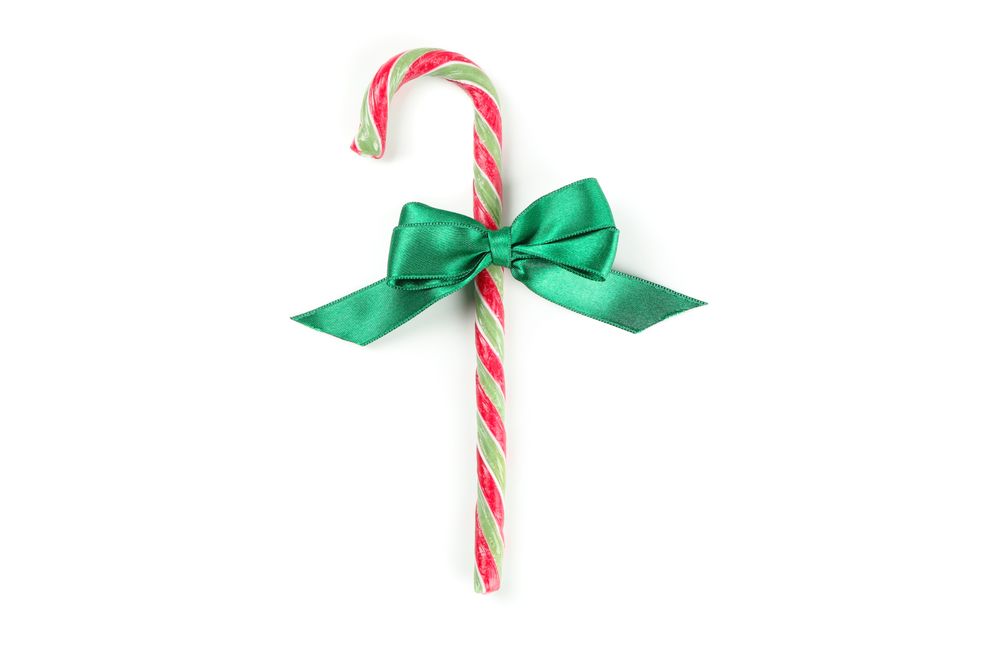 Sweet candy cane with bow isolated on blank background