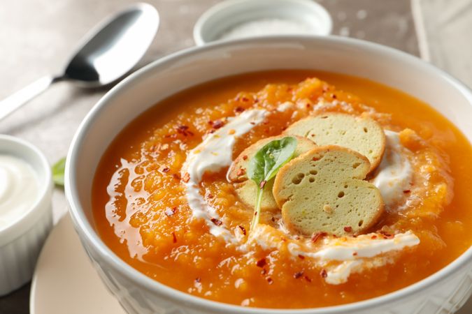 Close up of bowl of pumpkin soup on marble counter