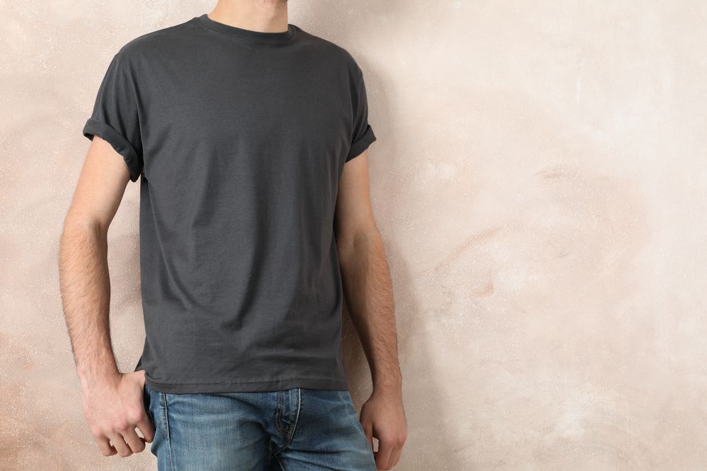 Men in blank grey t-shirt against color background, space for text