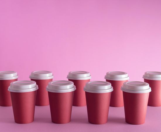 Disposable coffee cups on pink background