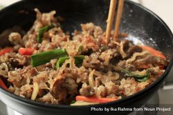Chopsticks in wok with stir fry of beef and glass noodles 48Vak0