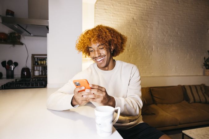 Young man using phone at home.