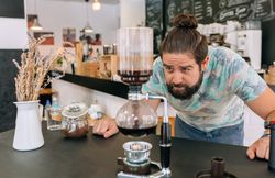 Barista skillfully brewing specialty coffee with Japanese siphon coffee maker