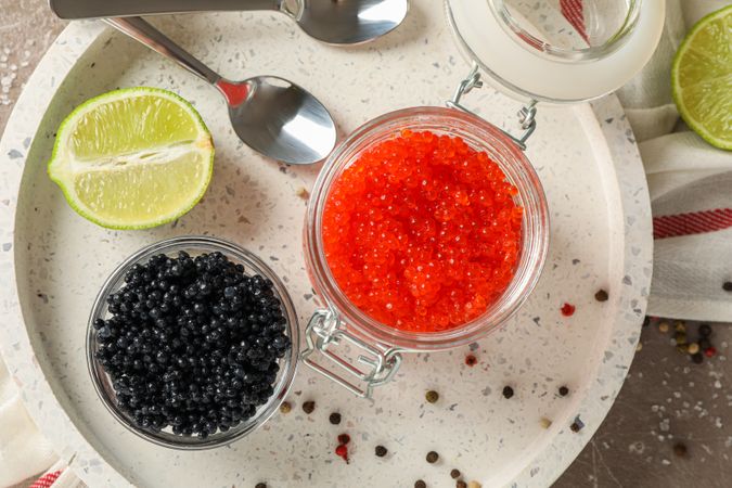 Appetizing composition with caviar and citrus on grey table, top view