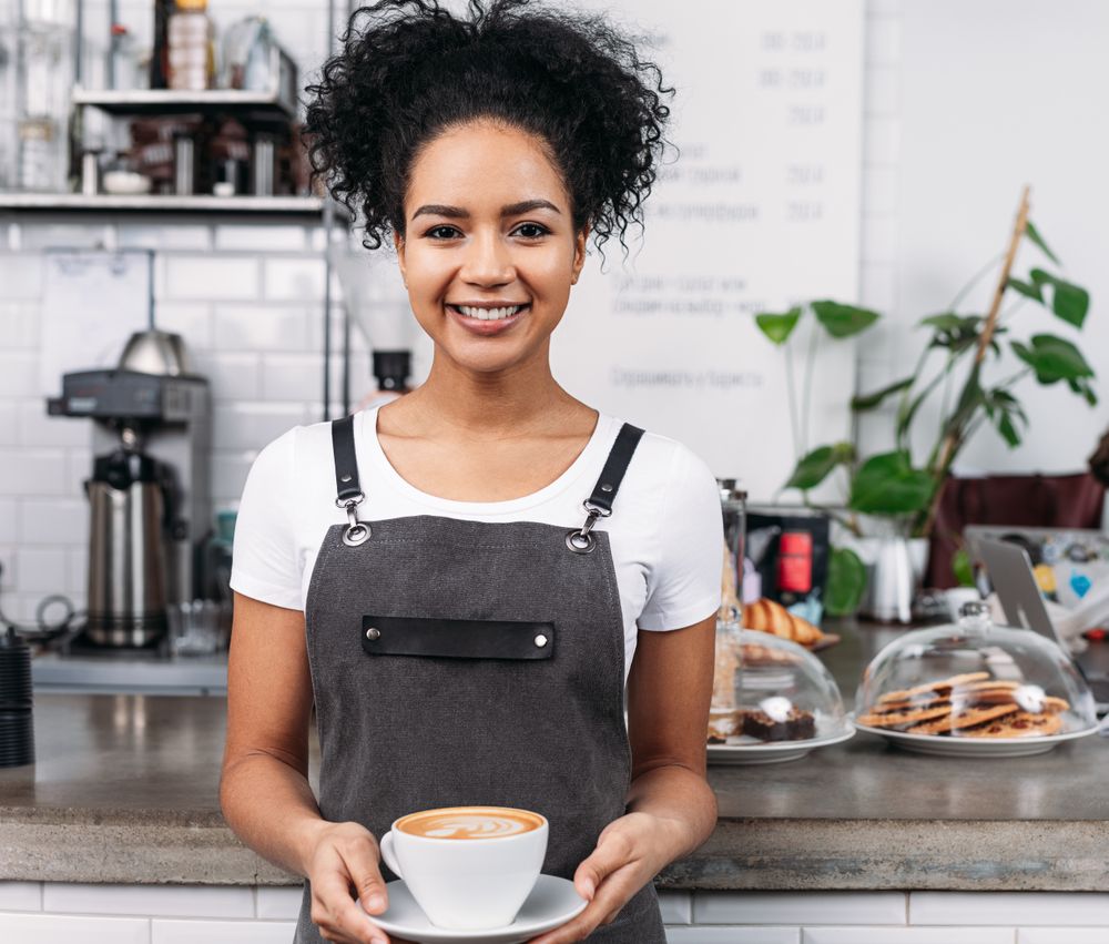Happy barista serving cappuccino