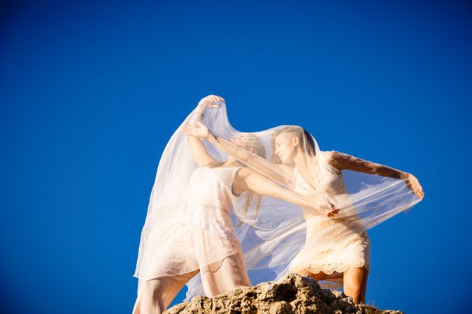 Young women with textile on stone