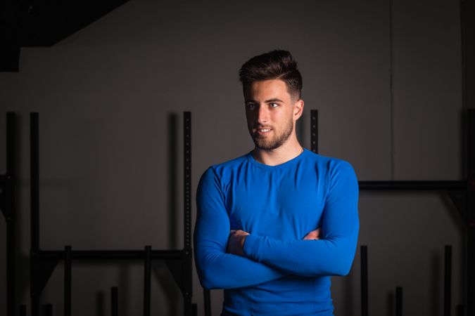 Smiling man with crossed hands in gym