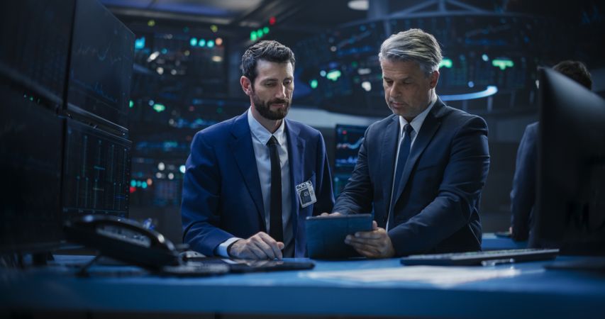 Two Successful Stock Exchange Brokers Working in an Office Building Surrounded by Computer Screens