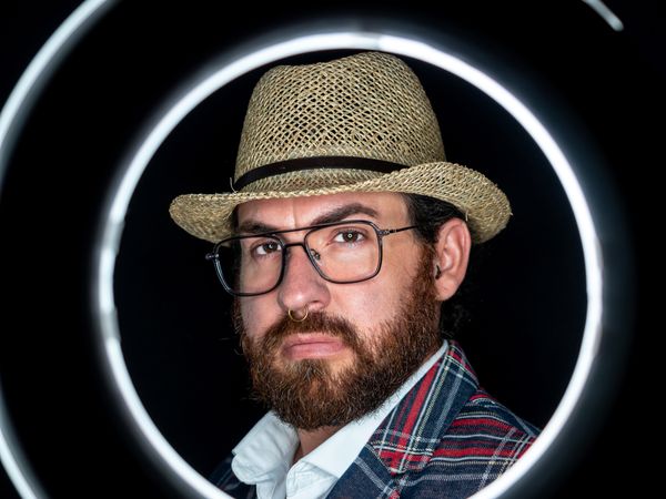 Stylish man in elegant suit behind special circle light