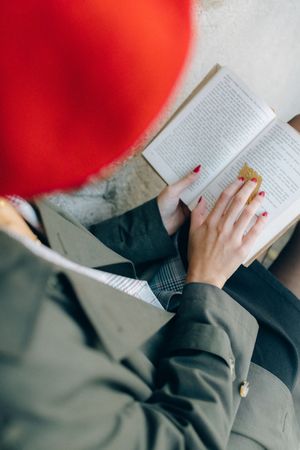 Top view of woman with red hat reading a book