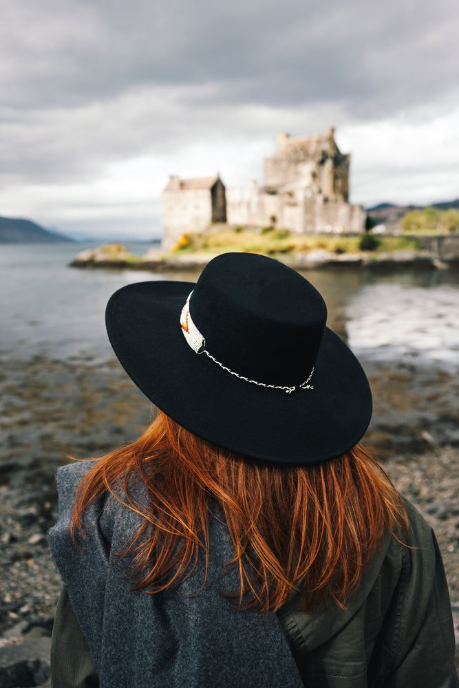 Smiling traveling woman contemplating castle landscape