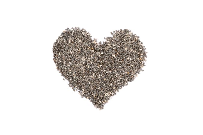 Heart laid out of chia seeds isolated on plain background