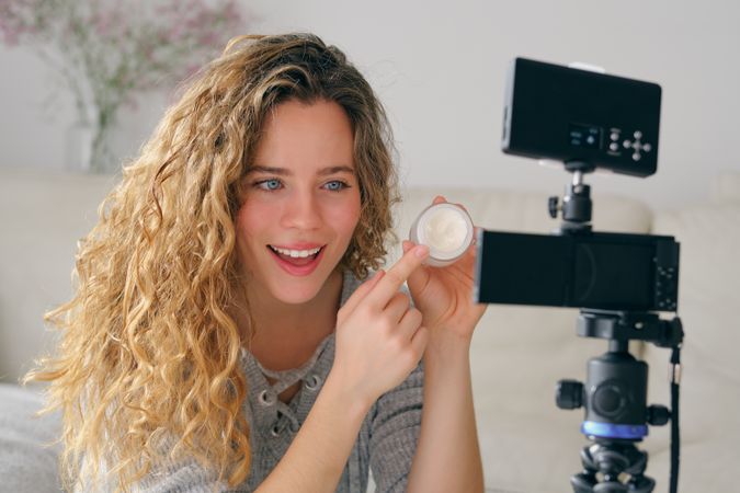 Female vlogger presenting beauty products on camera