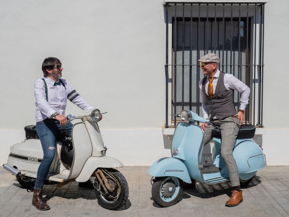 Trendy  men sitting on vintage scooters