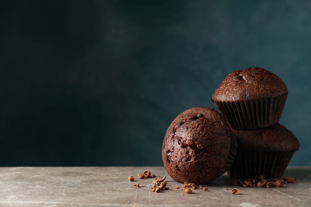 Delicious tasty muffins against blue background. Sweet food