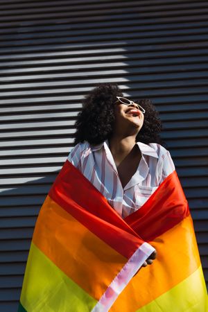 Smiling woman posing happily with the LGBT flag