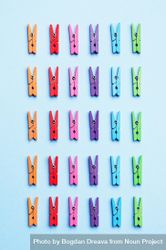 Rainbow colored clothes pins on light blue background 5z9dm0