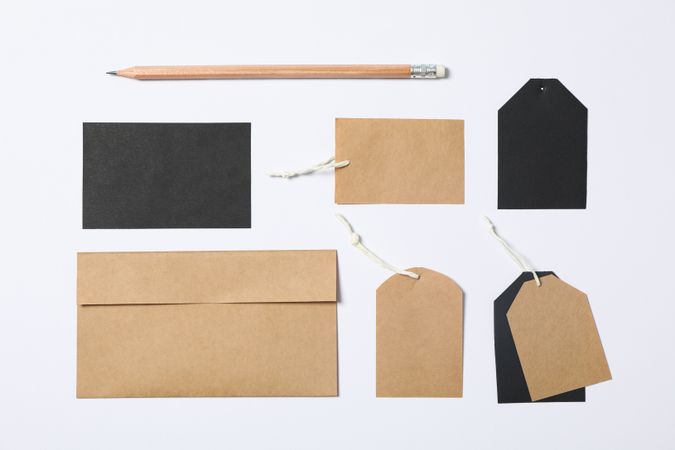 Flat lay composition with envelope, tags and pencil on plain background, mockup
