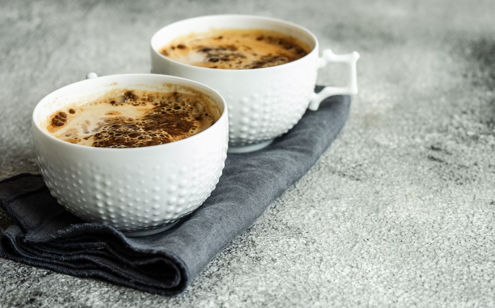 Side view of cups of morning coffee on grey counter