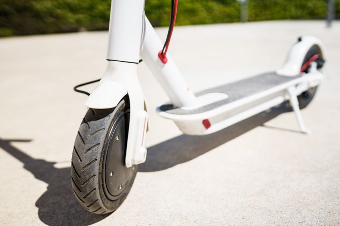 Close up of electric scooter front wheel parked in the sun