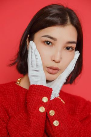 Portrait of young woman in red top and light gloves