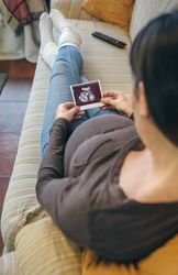 Pregnant looking at ultrasound of her baby