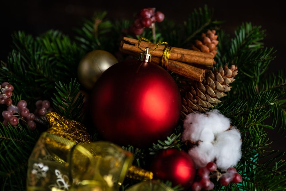 Close up of Christmas ornaments with red baubles, cinnamon, fir tree and cotton heads