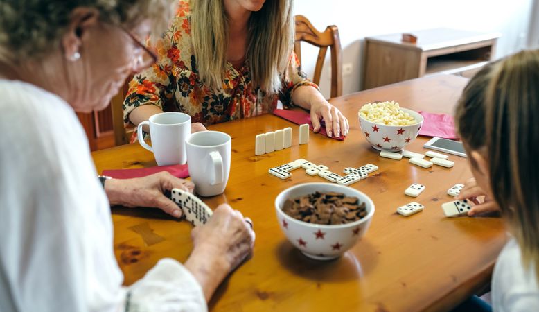 Three female generations playing domino