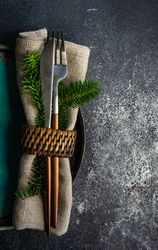 Christmas table setting with decorative fir wrapped with cutlery