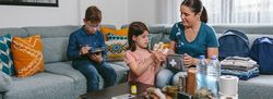 Mother preparing emergency backpack with her children