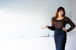 Female leader addressing the room in front of a dry erase board