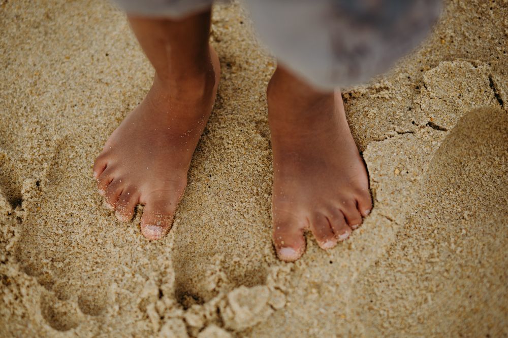 Crop Black kid standing on sand