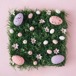 Pink and purple Easter eggs and natural grass and flowers