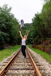 Woman walking along railway though greenery part of road