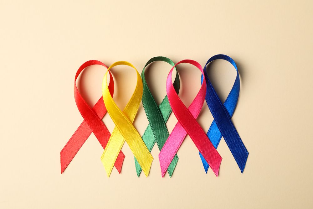 Flat lay composition with awareness ribbons on color background, space for text.