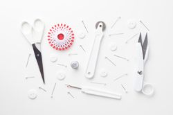 Top view of sewing tools organized over light background