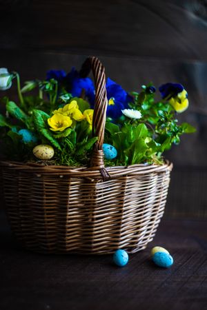 Basket of flowers with pastel decorative mini eggs
