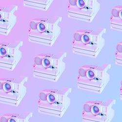 Pattern of vintage camera in light colored paint and with vibrant holograph