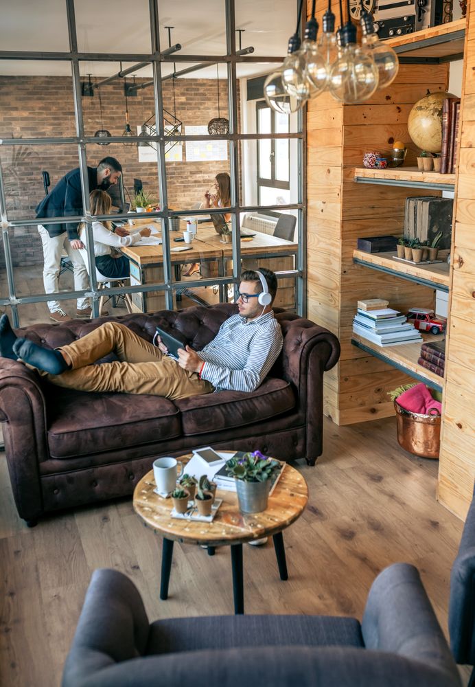 Businessman lying on an office sofa with tablet