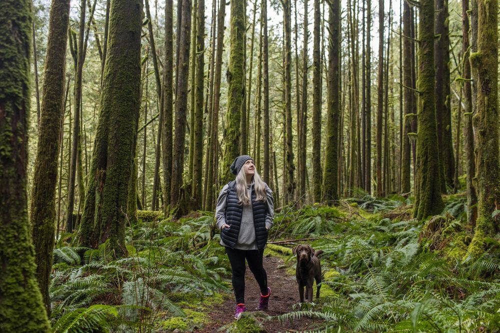 Woman with w brown dog in the woods